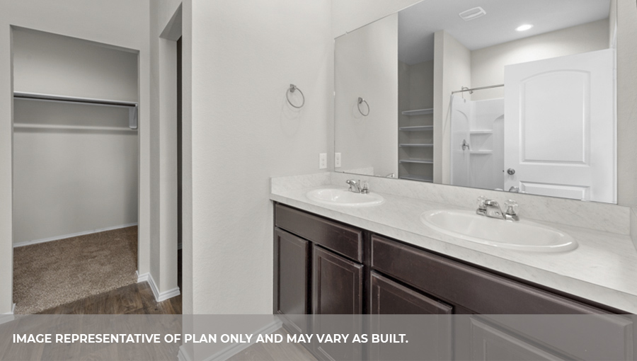 Primary bathroom with double sink and spacious walk-in closet.