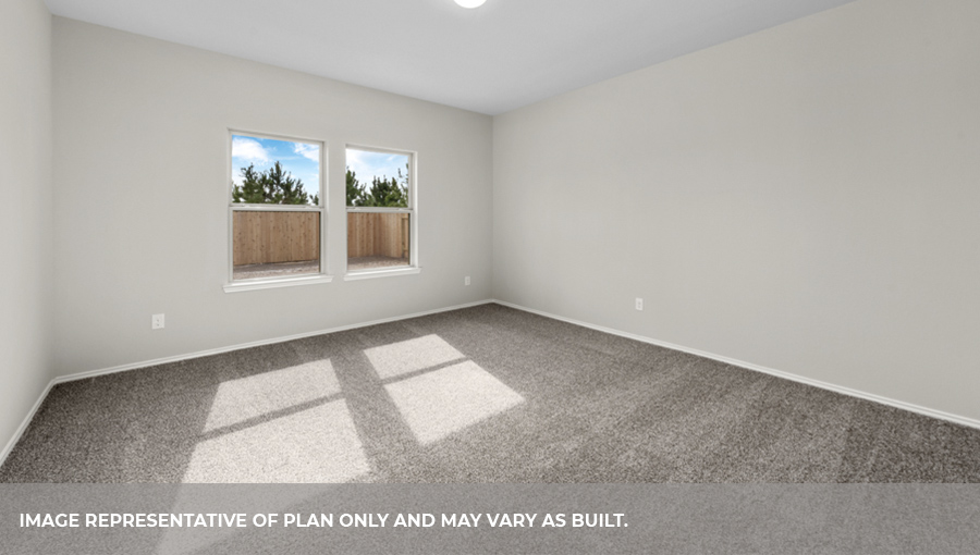 Primary bedroom with carpet flooring and bright windows.