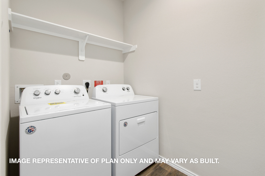 Utility room with overhead storage space.