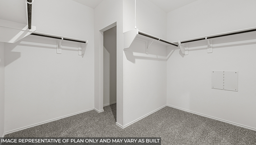 Primary bedroom walk-in closet with carpet flooring in Mill Creek community in Hills of Westlake