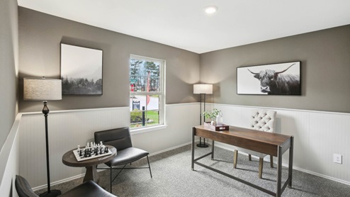 Secondary bedroom with windows, white walls, and light carpet.