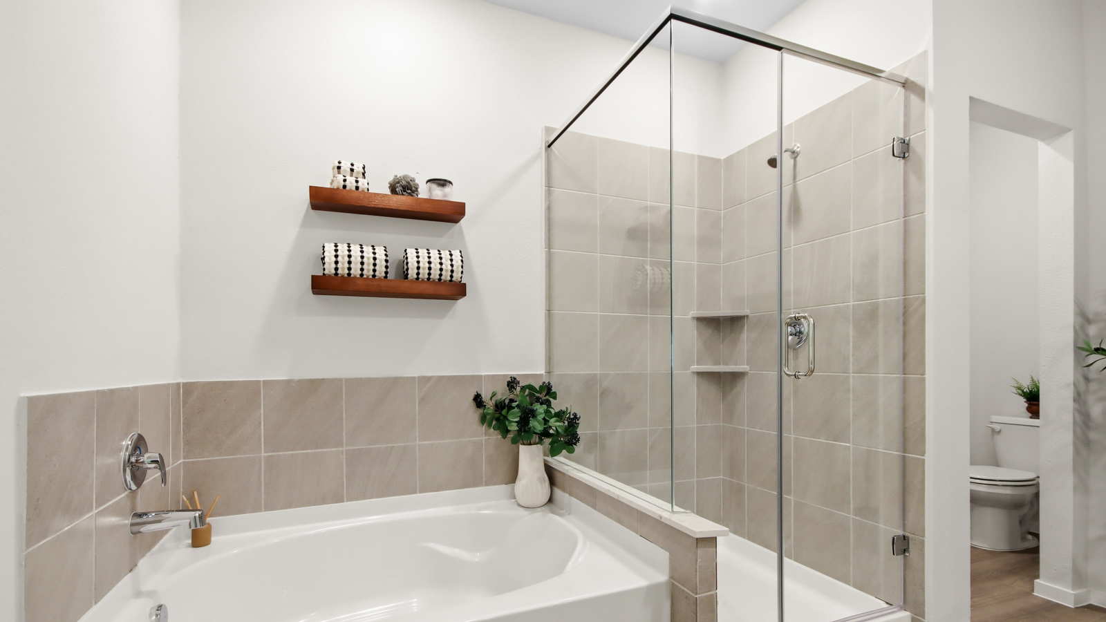 Primary bathroom with soaker tub and tile shower with semi frameless glass in Willis TX