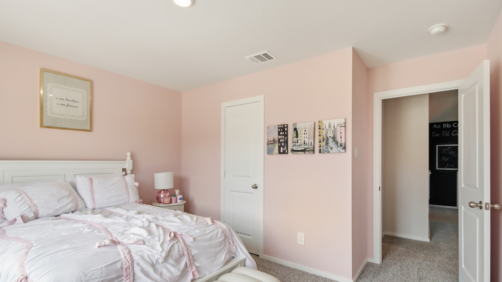 Second level secondary bedroom with carpet flooring and bright window