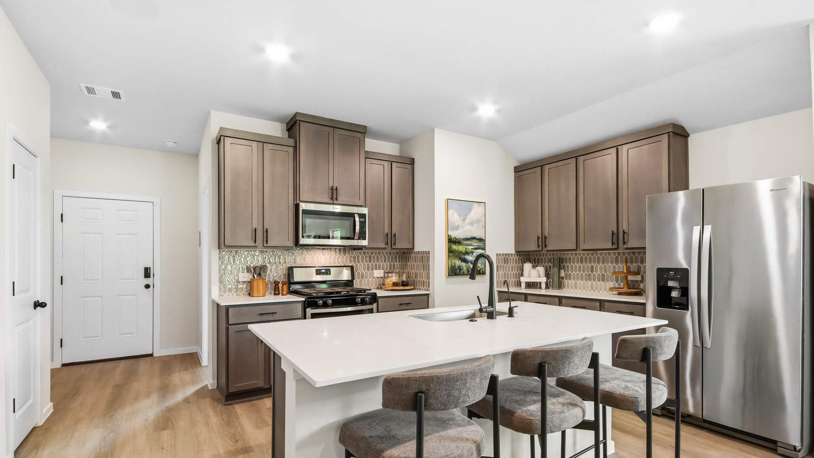 Kitchen with quartz countertops and an island and vinyl floor