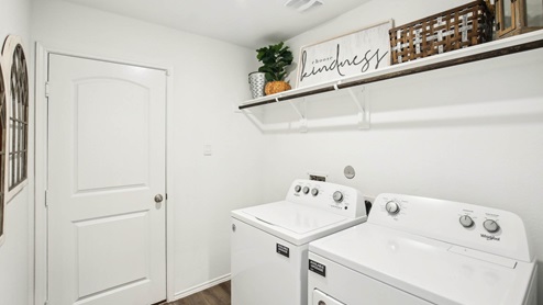 Laundry room with white walls and vinyl wood flooring.