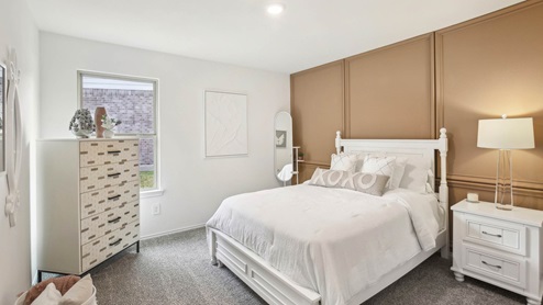Secondary bedroom with windows, white walls, and light carpet.