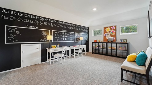 Large game room with windows, white walls, and light carpet.