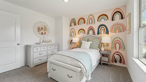 Secondary bedroom with windows, white walls, and light carpet.