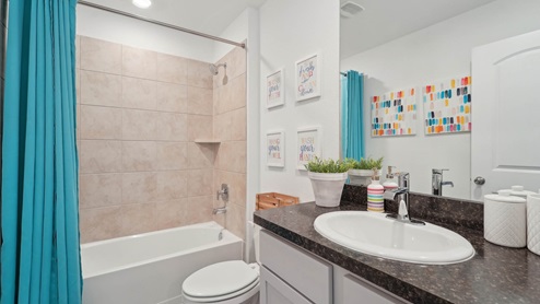 Secondary bathroom with a shower and tub combo, white walls, and vinyl wood flooring.
