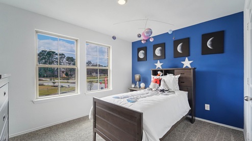 Secondary bedroom with windows, white walls, and light carpet.