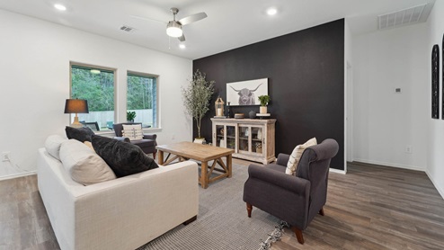 Open living room with windows, white walls, and vinyl wood flooring.