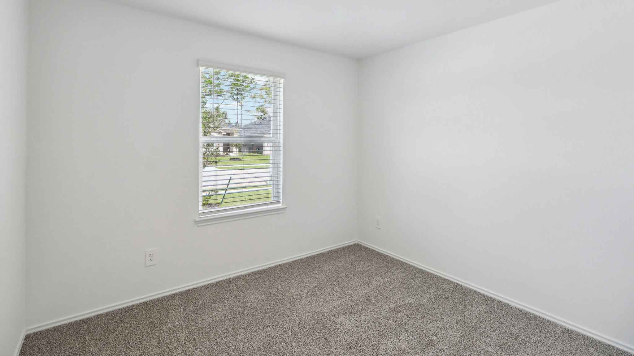 Secondary bedroom with carpet flooring and a bright window.