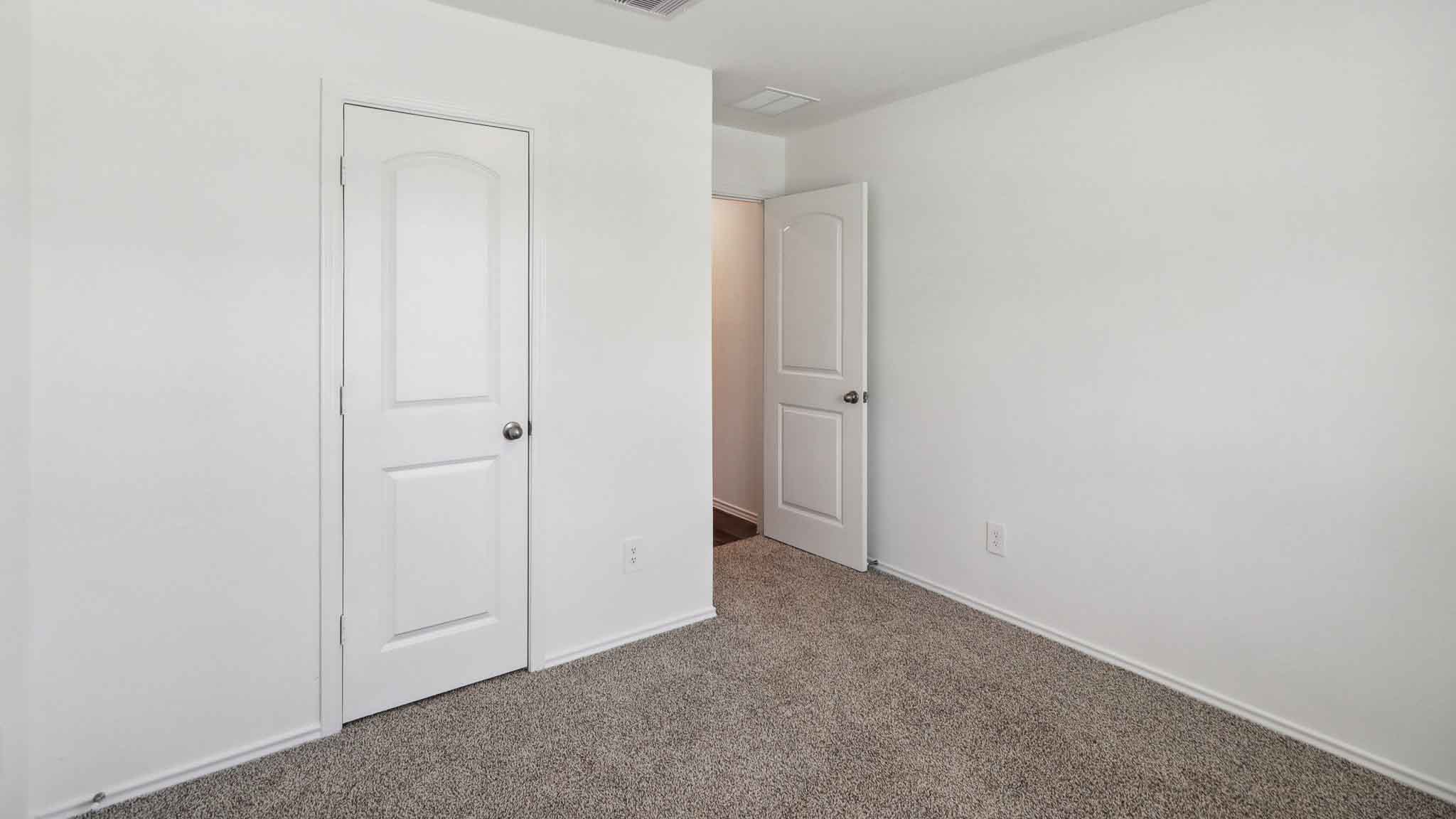 Secondary bedroom with carpet flooring.