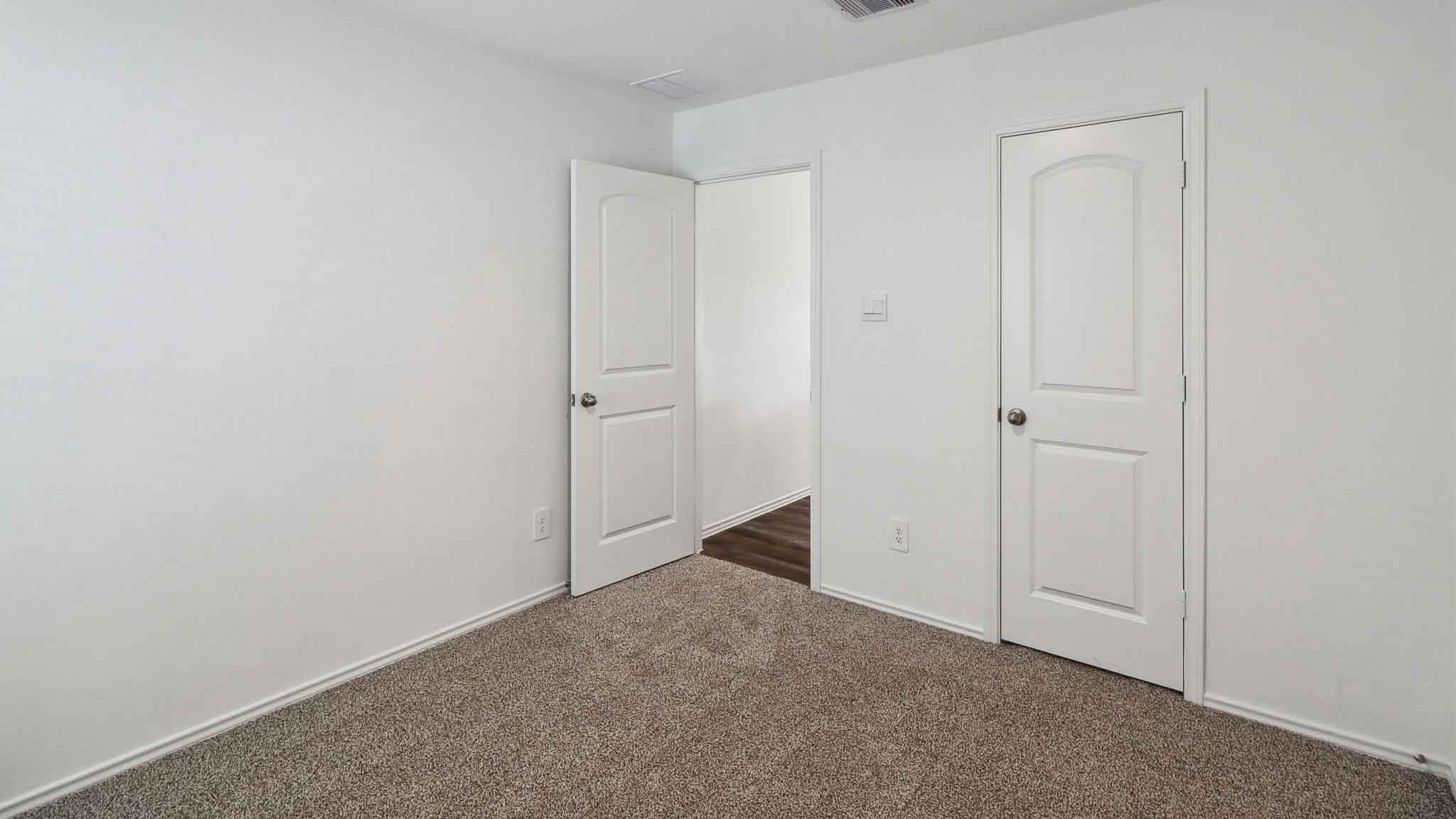 Secondary bedroom with carpet flooring.