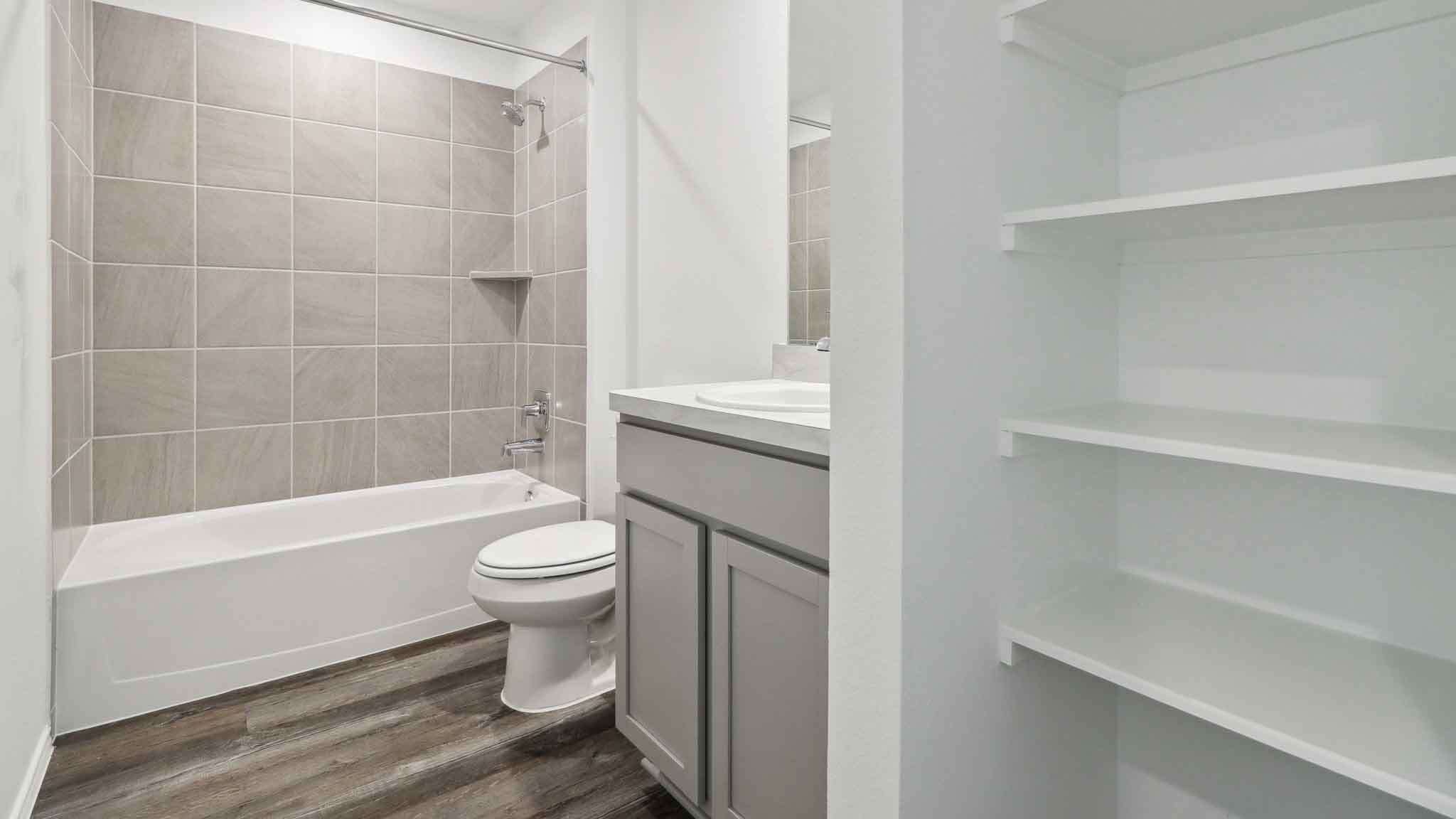 Secondary bathroom with a tile tub/shower combo, and a linen nook.