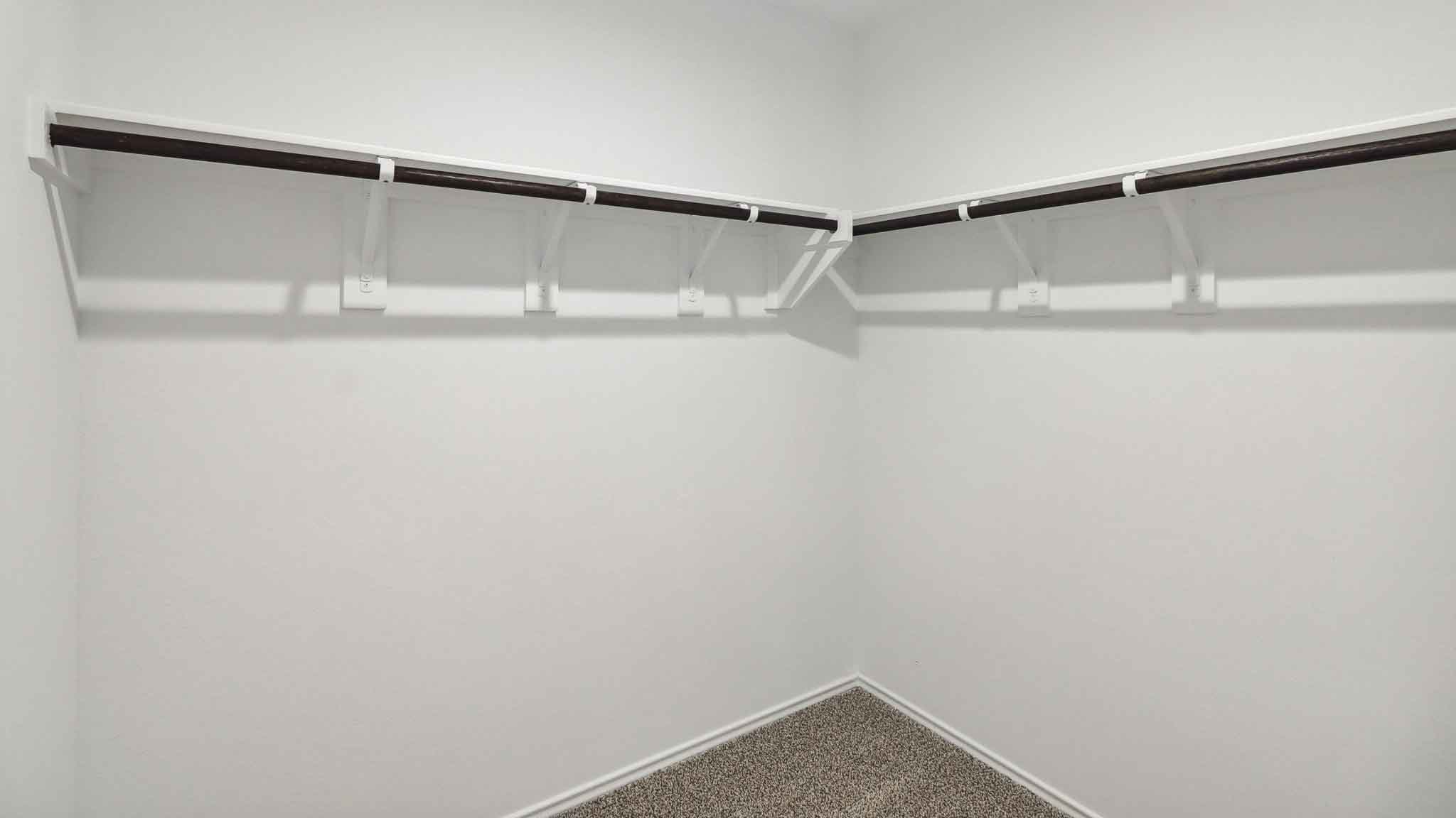 Walk-in closet with carpet flooring and overhead storage space.