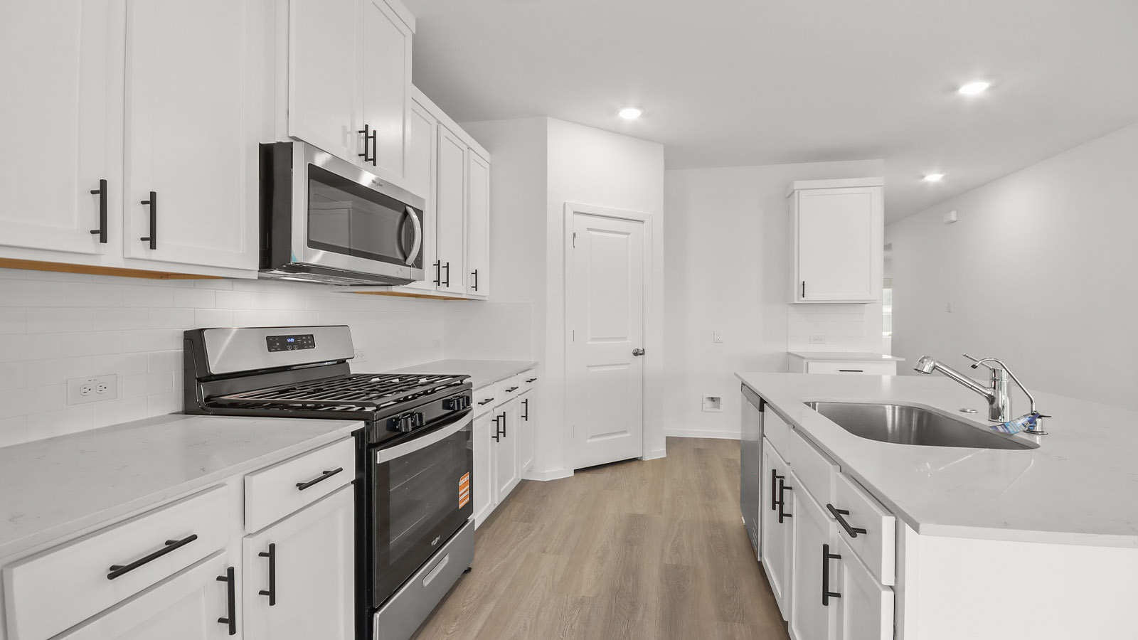 Kitchen with quartz countertops and marden hardware and an island and vinyl floor