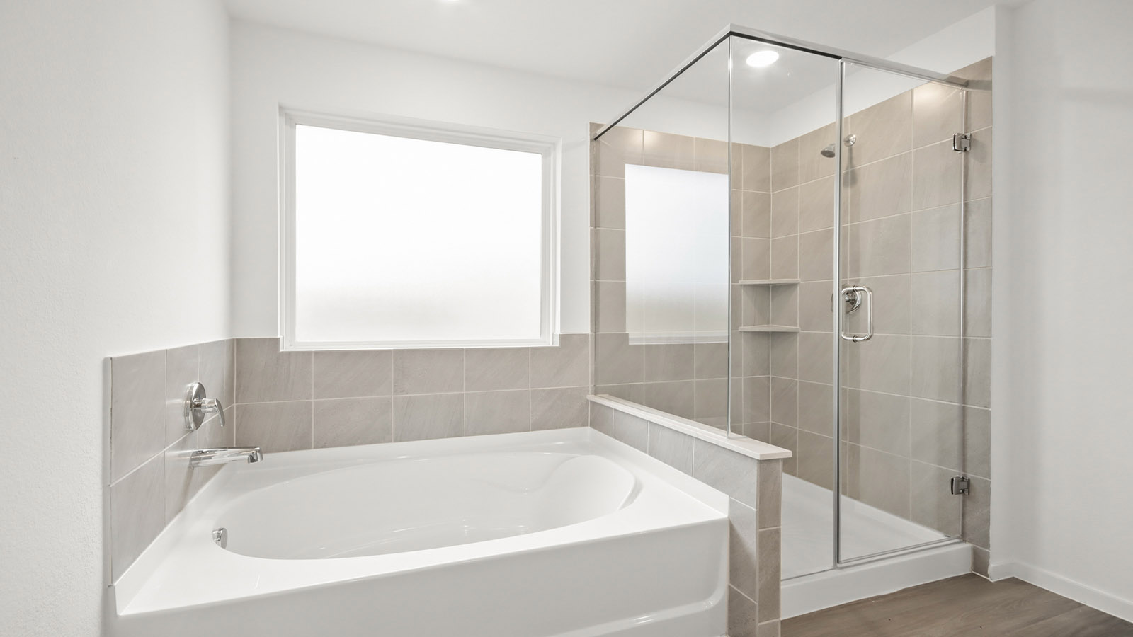 Primary bathroom with soaker tub and tile shower with semi frameless glass in Magnolia TX