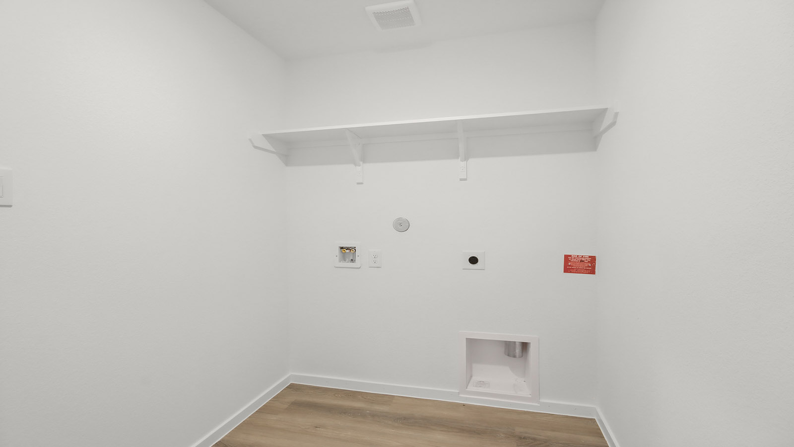 Utility room with storage located off the entry hallway and garage door
