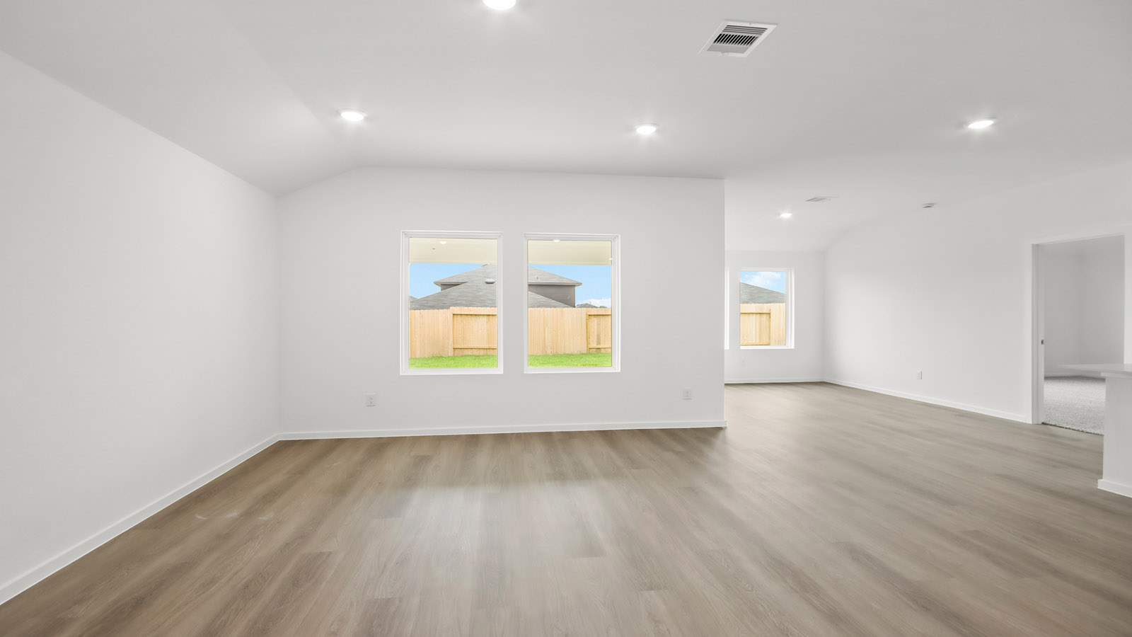 Spacious living area with vinyl flooring and bright windows in Magnolia TX