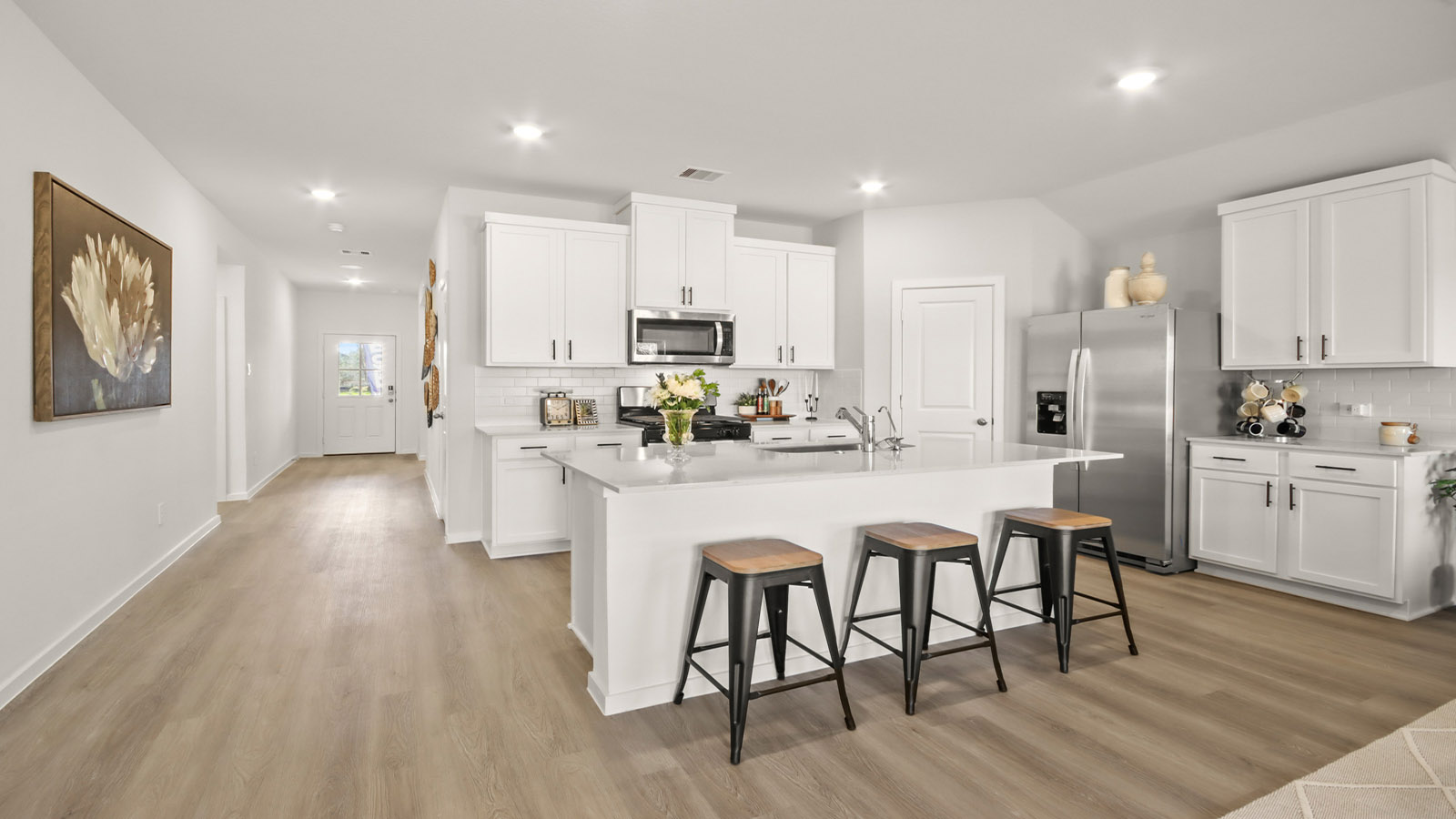 Kitchen with quartz countertops and marden hardware and an island and vinyl floor