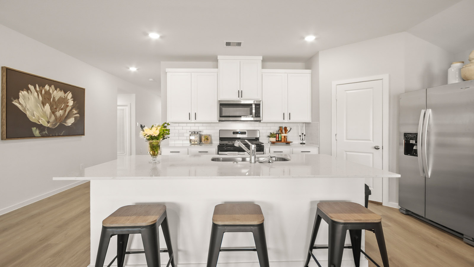 Kitchen with quartz countertops and marden hardware and an island and vinyl floor
