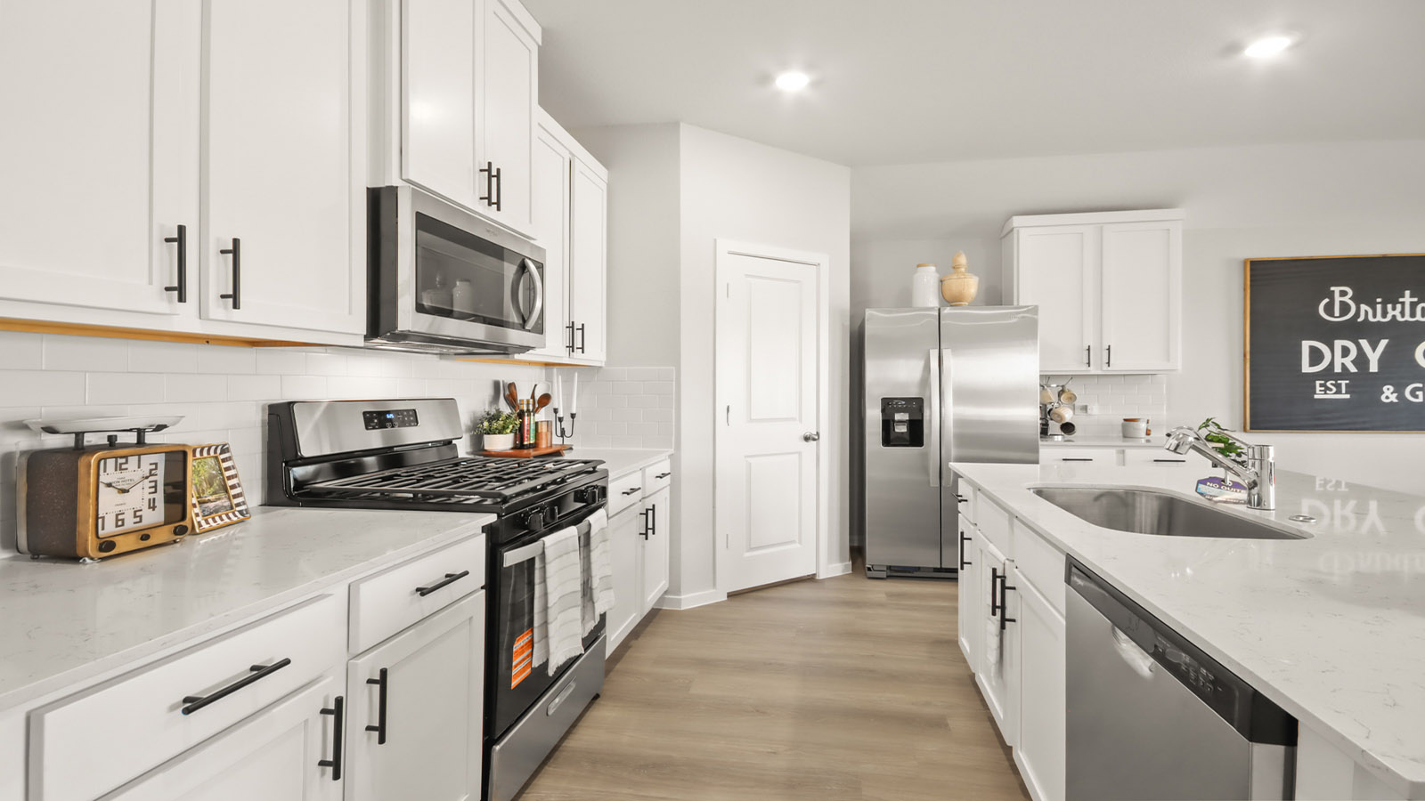 Kitchen with quartz countertops and marden hardware and an island and vinyl floor