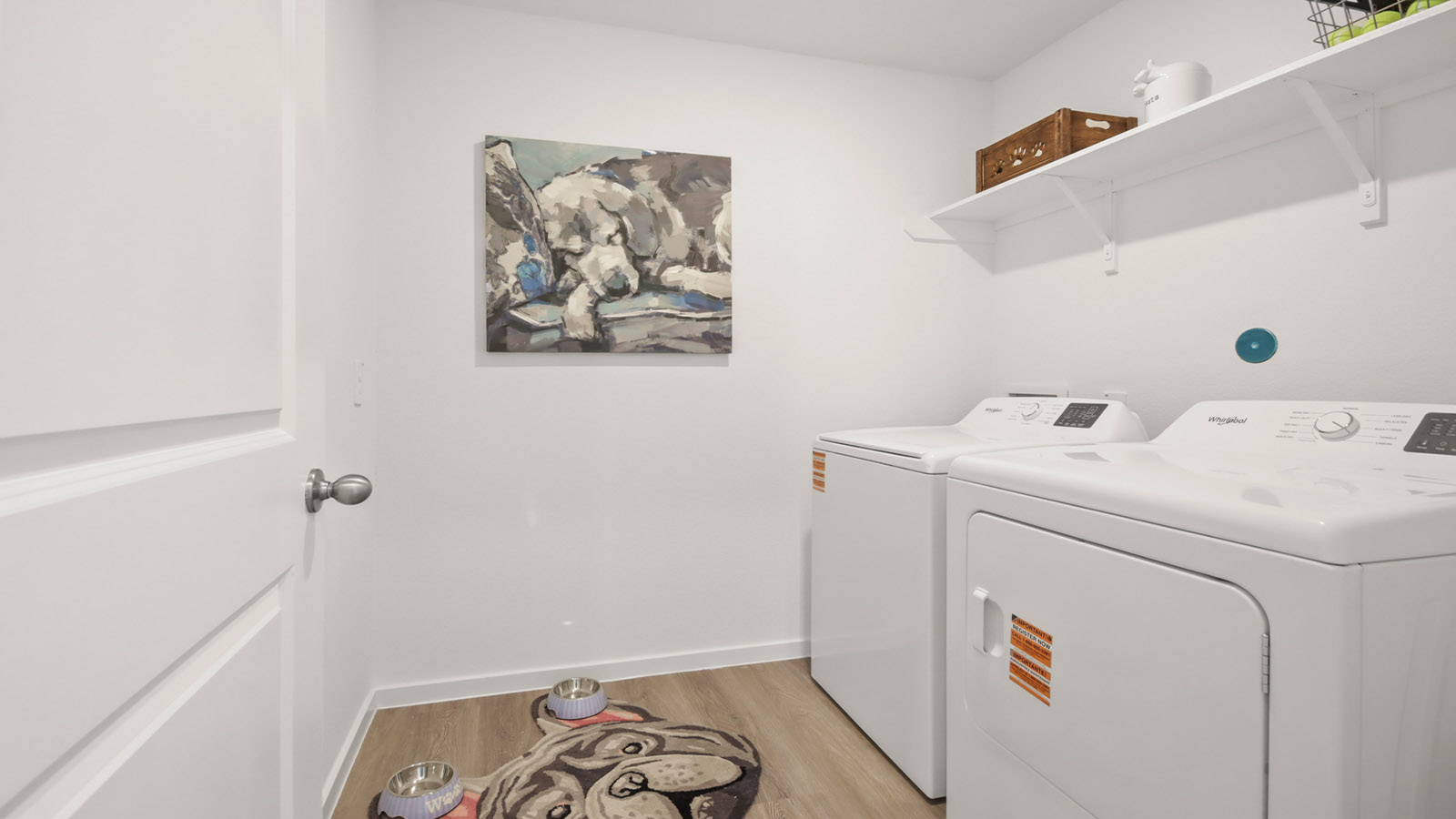 Utility room with storage located off the entry hallway and garage door