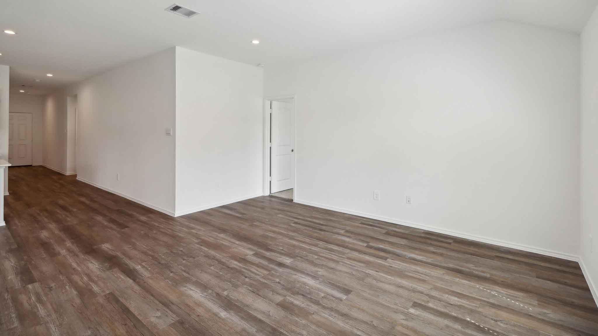 Open concept living and dining space with vinyl flooring.