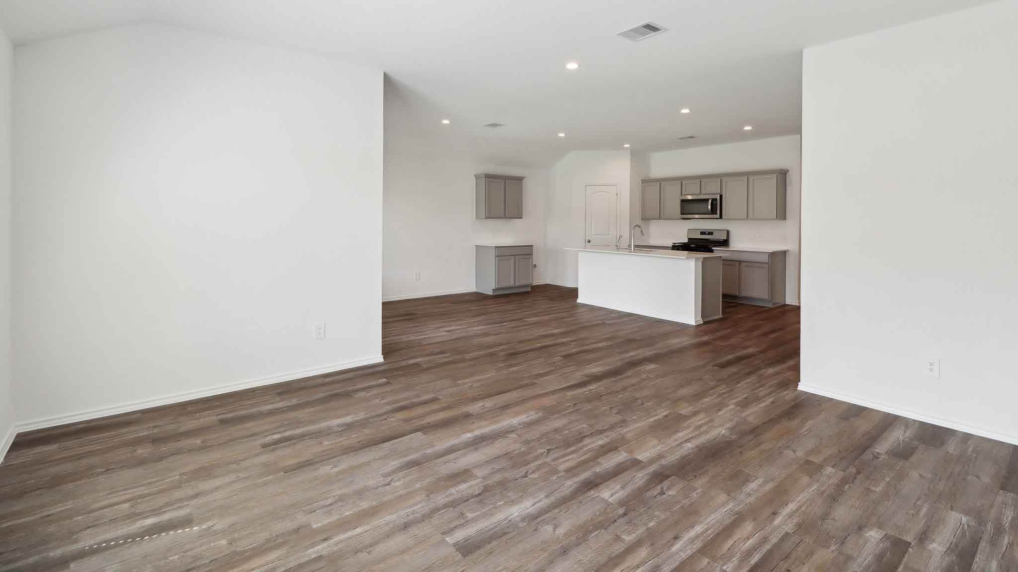 Open concept living and dining space with vinyl flooring.