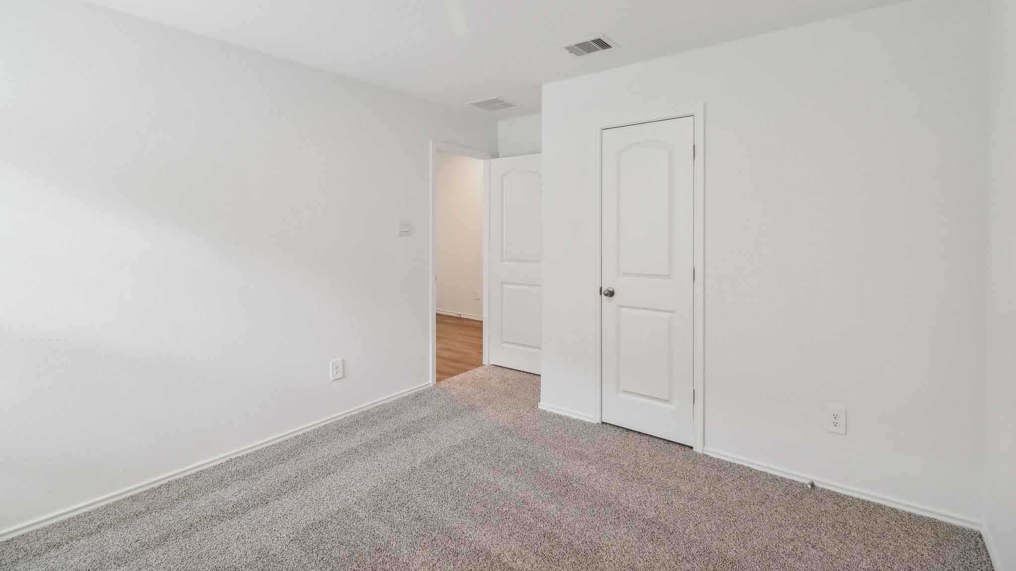 Secondary bedroom with carpet flooring.