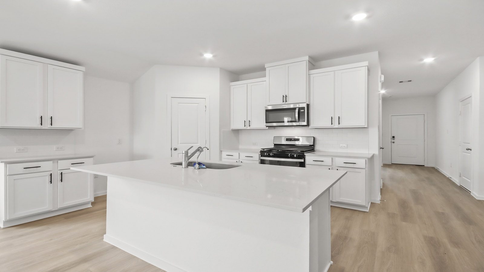 Kitchen with quartz countertops and marden hardware and an island and vinyl floor