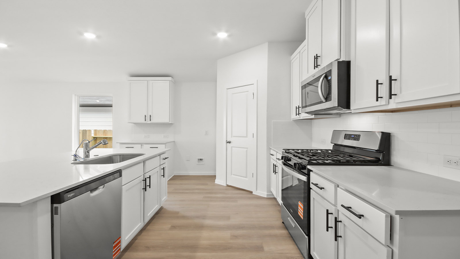 Kitchen with quartz countertops and marden hardware and an island and vinyl floor