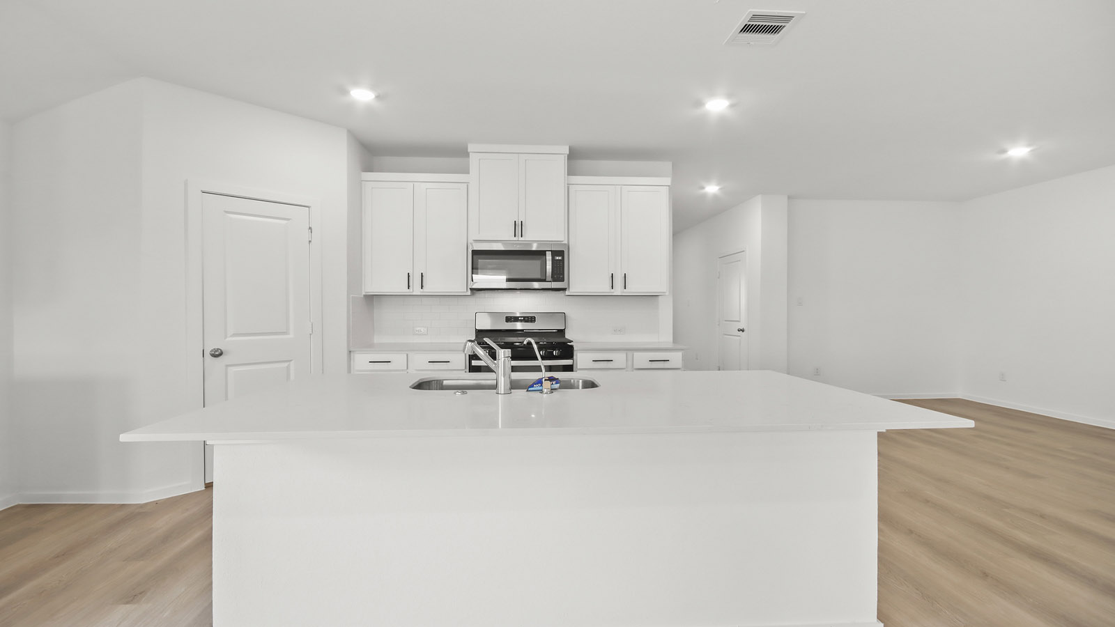 Kitchen with quartz countertops and marden hardware and an island and vinyl floor