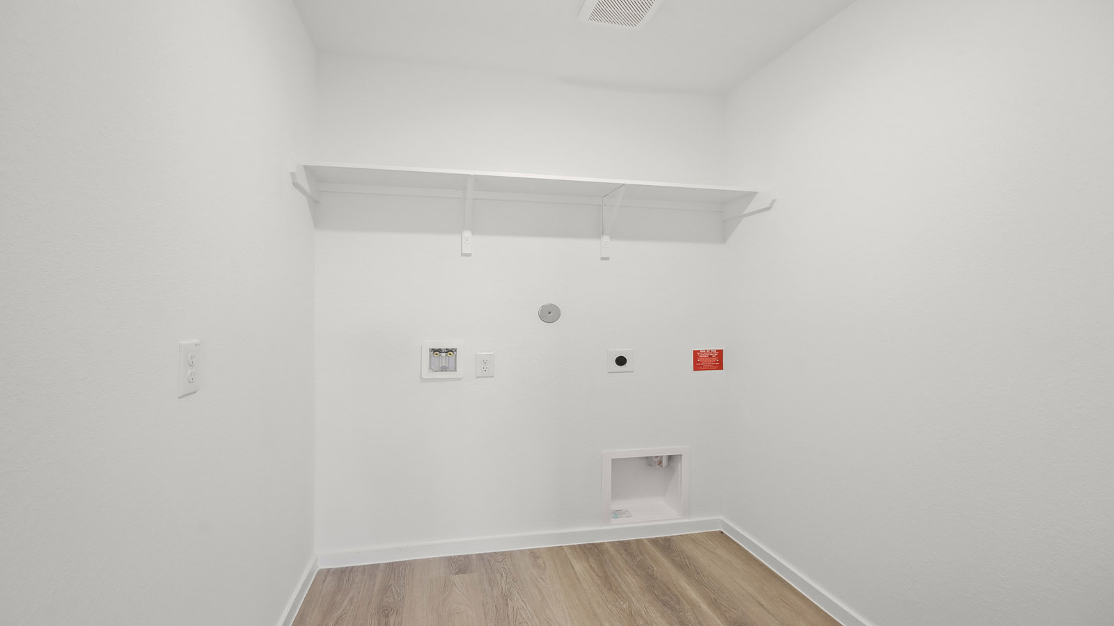 Utility room with storage located off the entry hallway and garage door