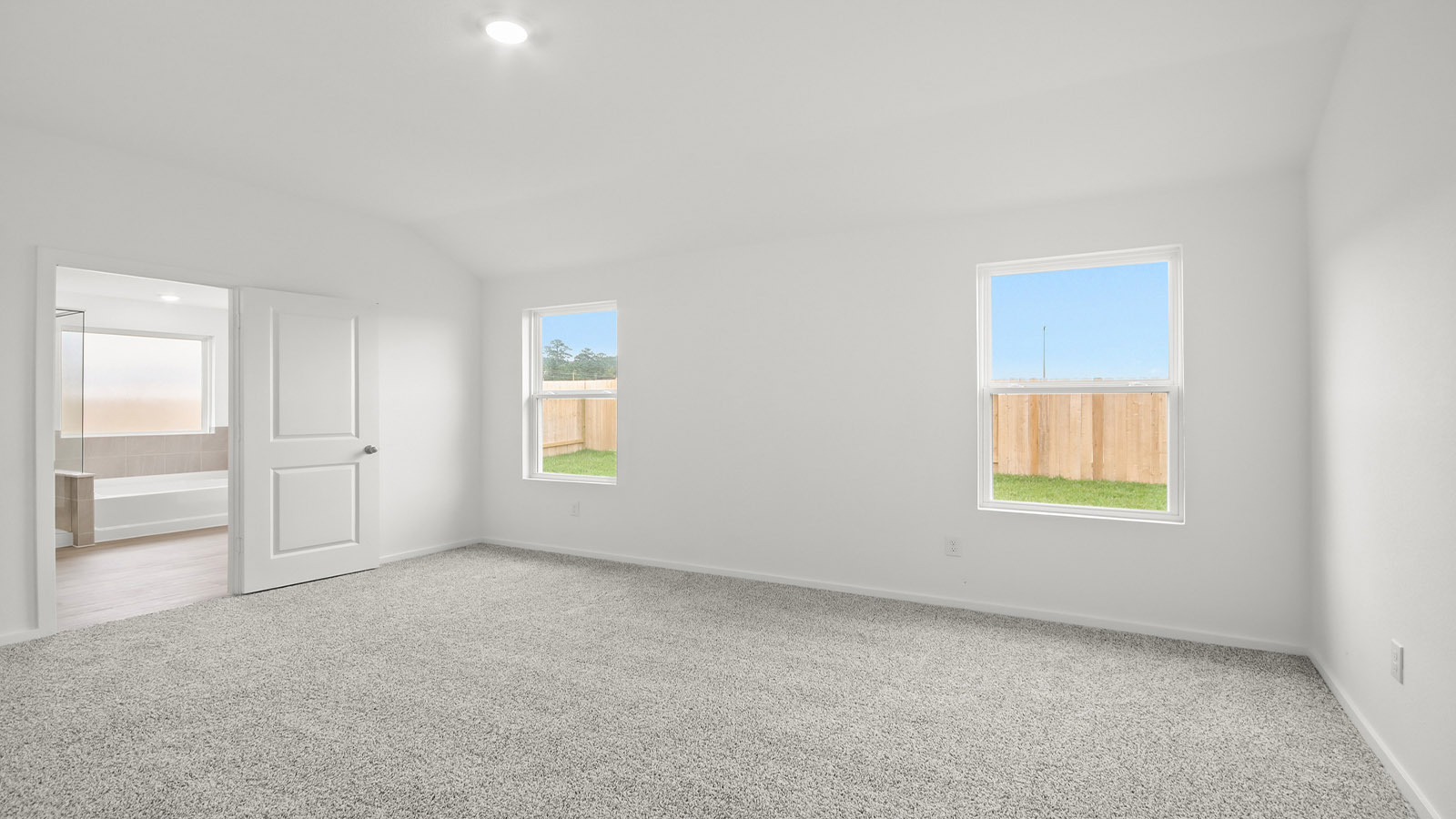Large Primary bedroom with shag carpet flooring and bright window