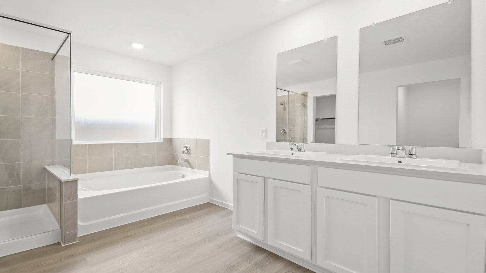 Primary bathroom with soaker tub and tile shower with semi frameless glass in Magnolia TX