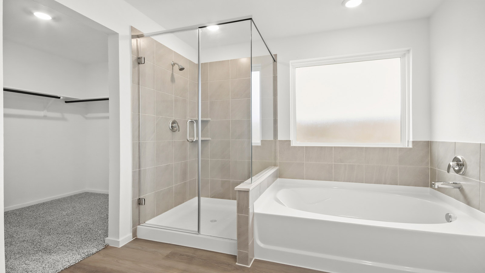 Primary bathroom with soaker tub and tile shower with semi frameless glass in Magnolia TX