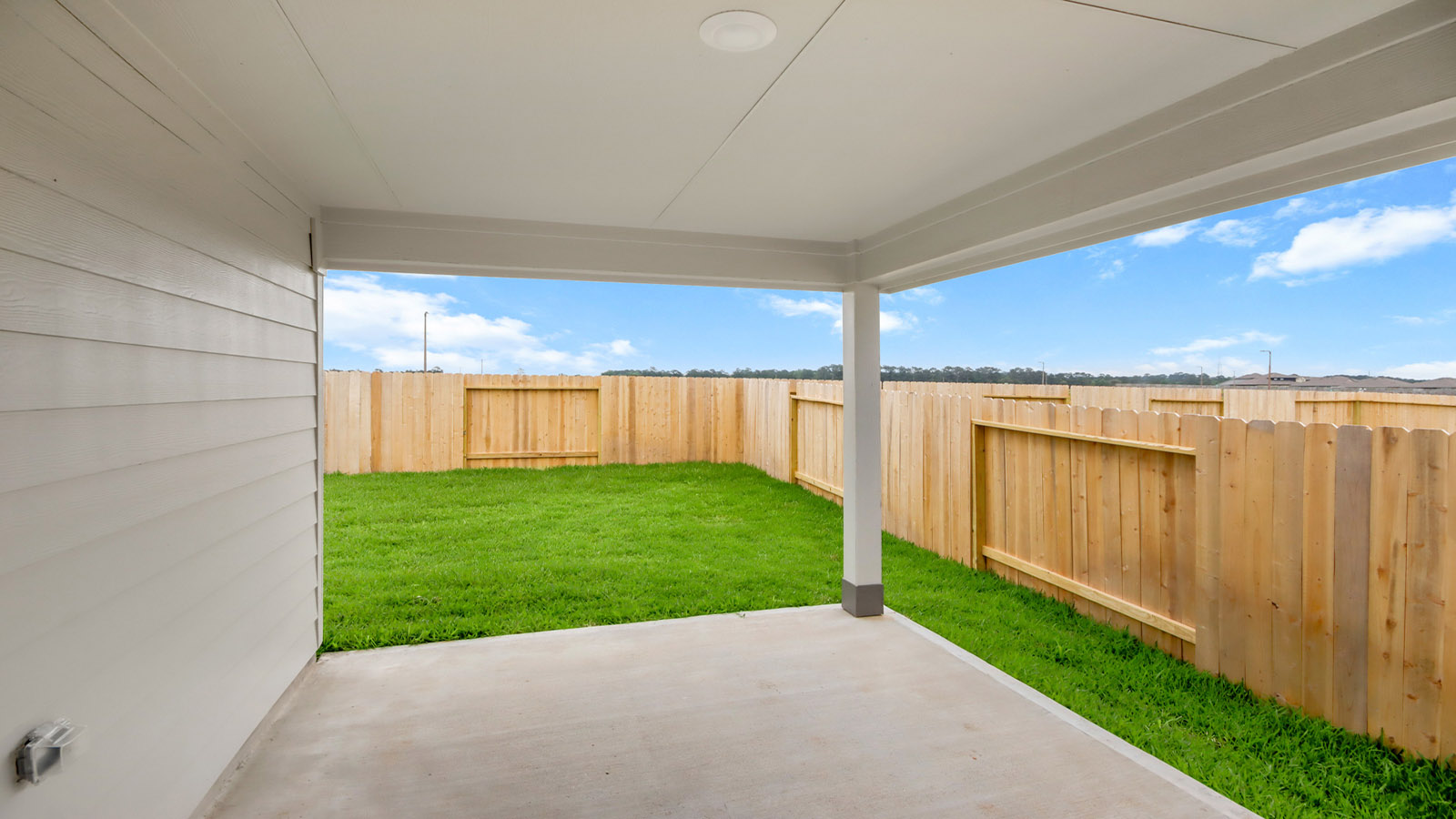 covered patio with jamies hardie siding and overhead lighting