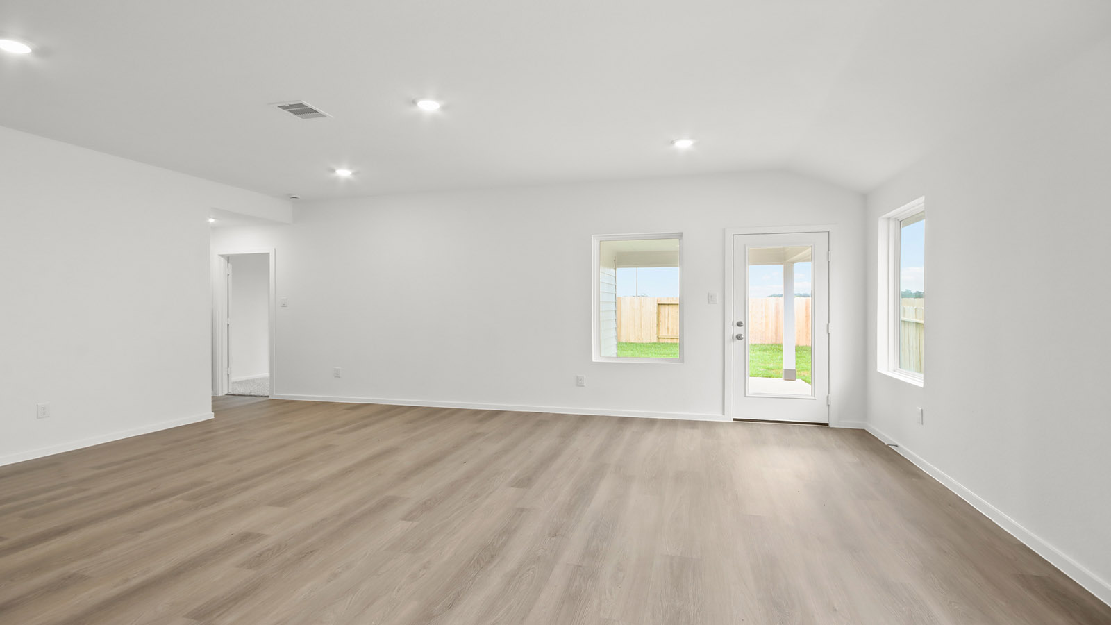 Spacious living area with vinyl flooring and bright windows in Magnolia TX