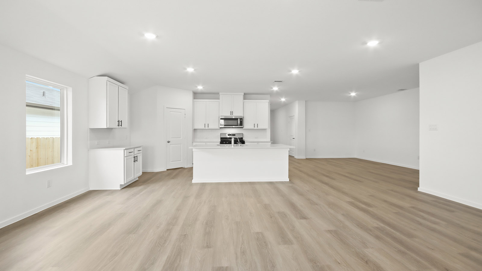 Kitchen with quartz countertops and marden hardware and an island and vinyl floor