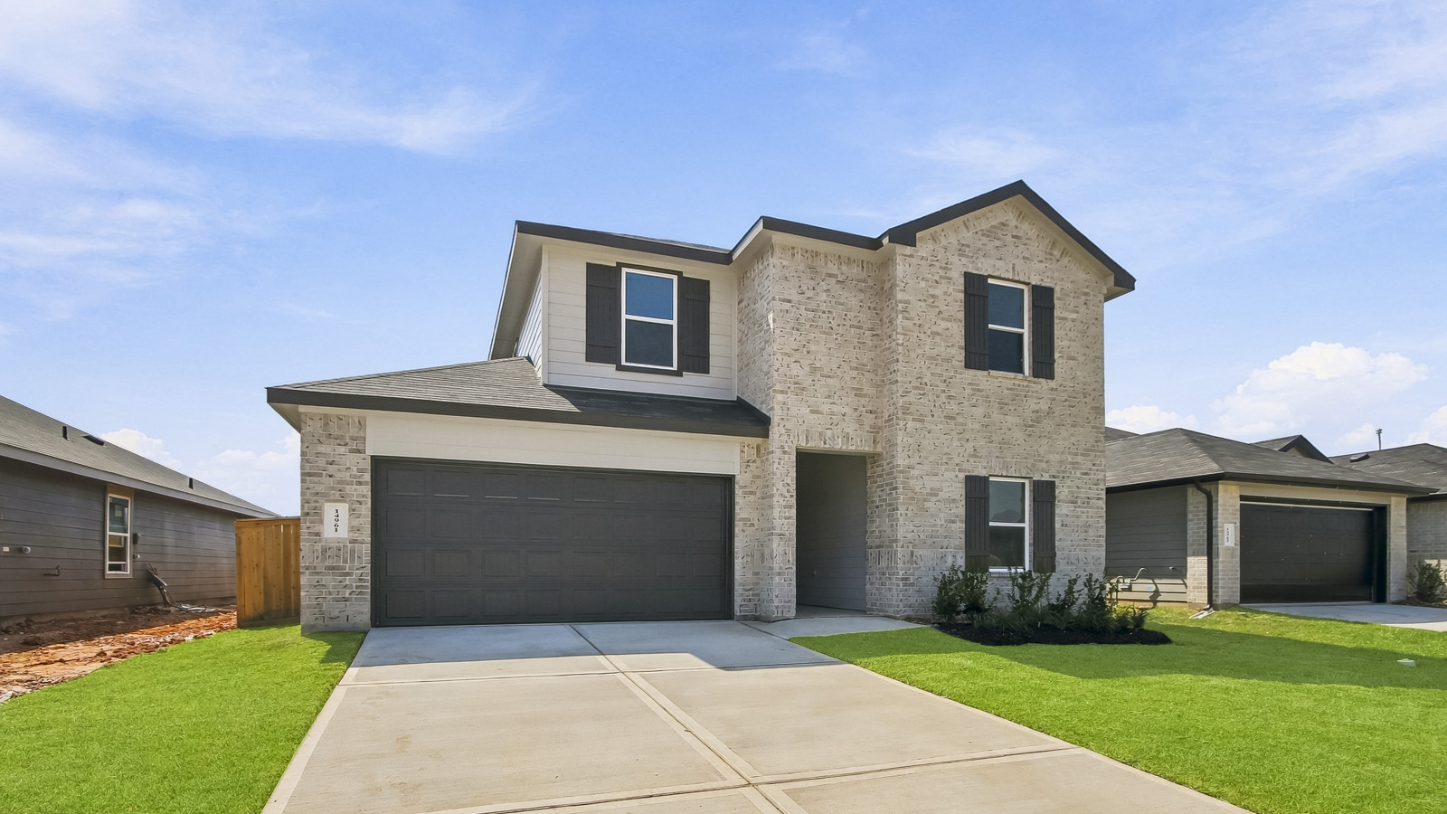 two stroy home with off whote brick and black trim