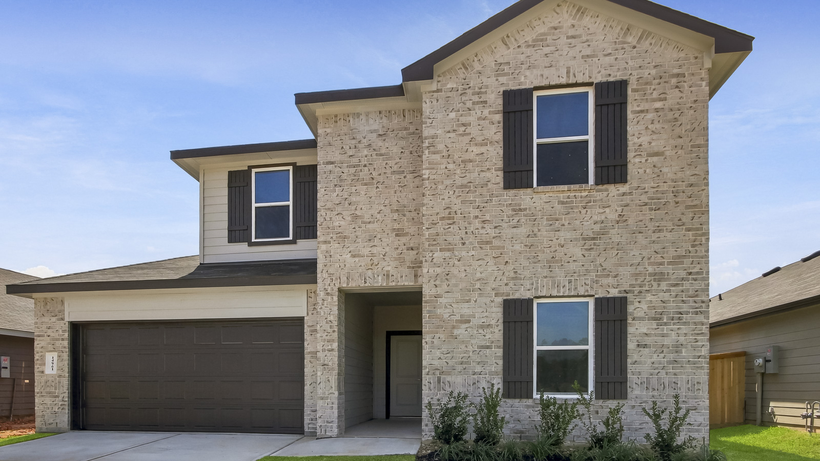 two stroy home with off whote brick and black trim