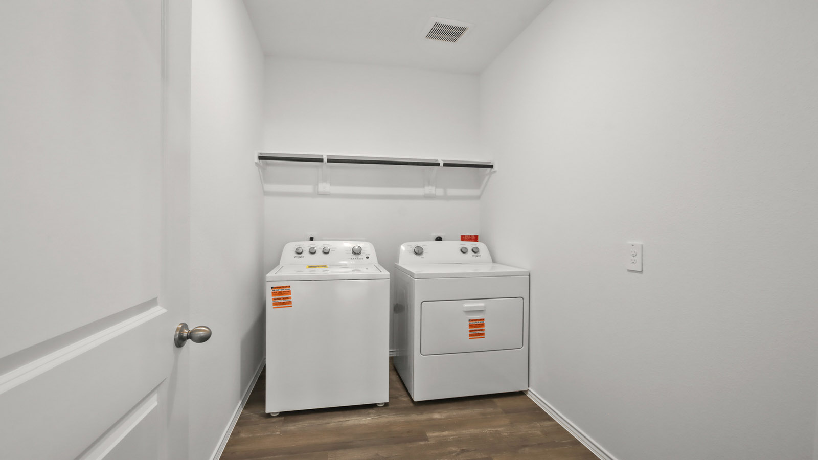 Utility room with storage located off the entry hallway and garage door