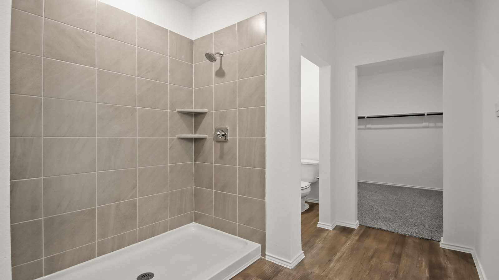 Primary bathroom with stand-alone shower with tiles and semi frameless glass in Magnolia TX