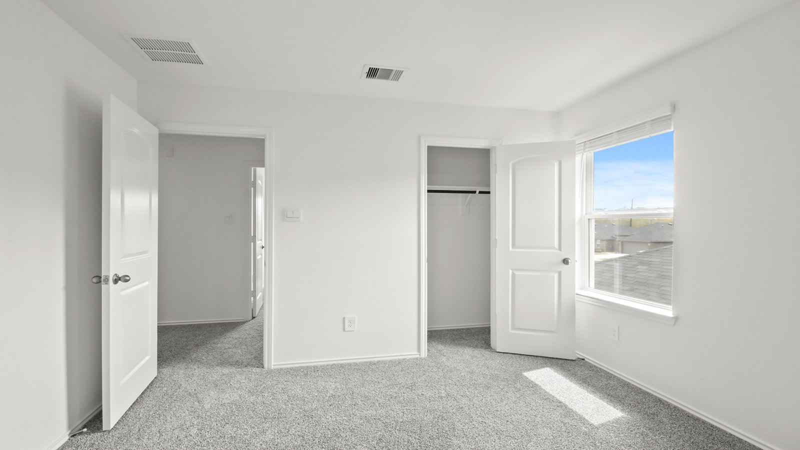 Secondary bedroom with shag carpet flooring and bright window