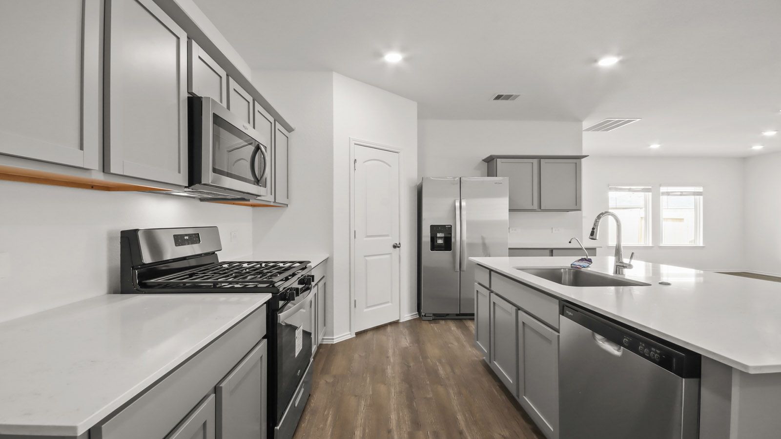 Kitchen with quartz countertops and marden hardware and an island and vinyl floor