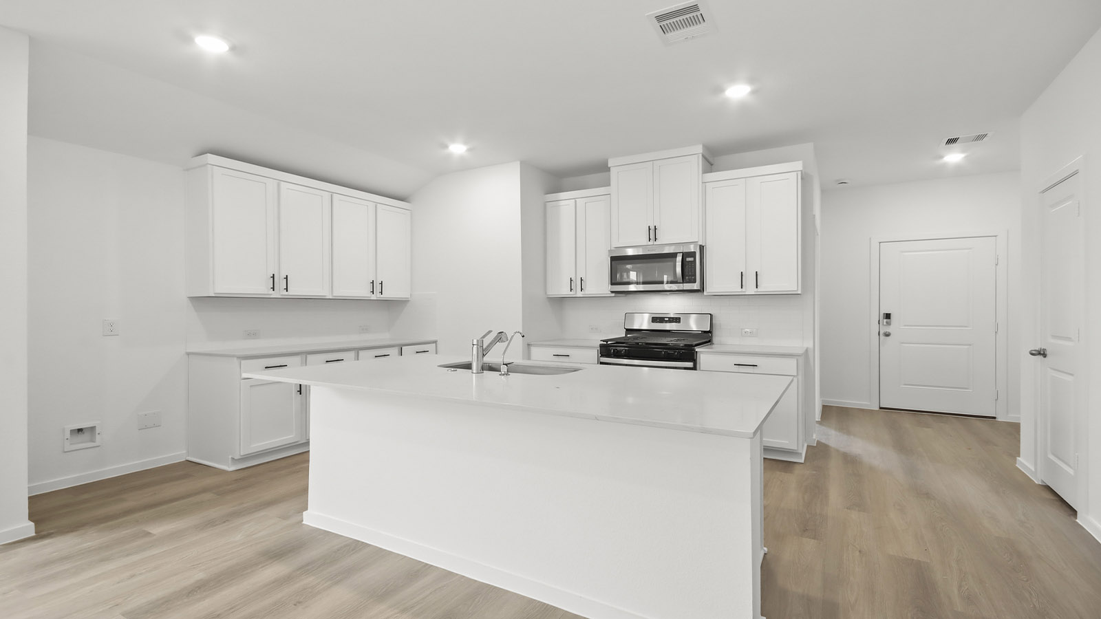 Kitchen with quartz countertops and marden hardware and an island and vinyl floor