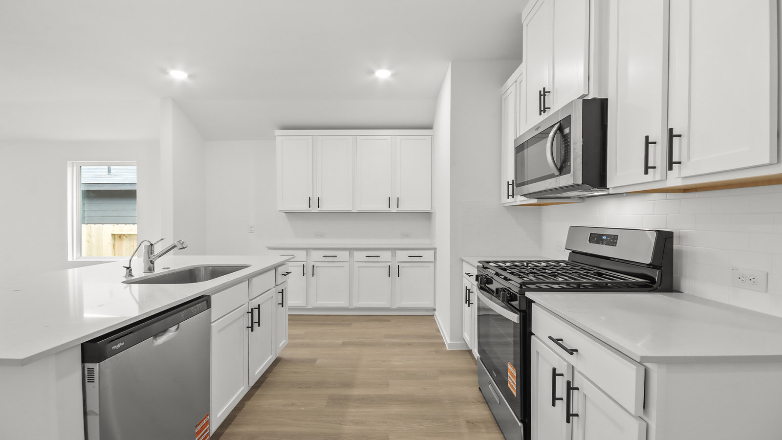 Kitchen with quartz countertops and marden hardware and an island and vinyl floor