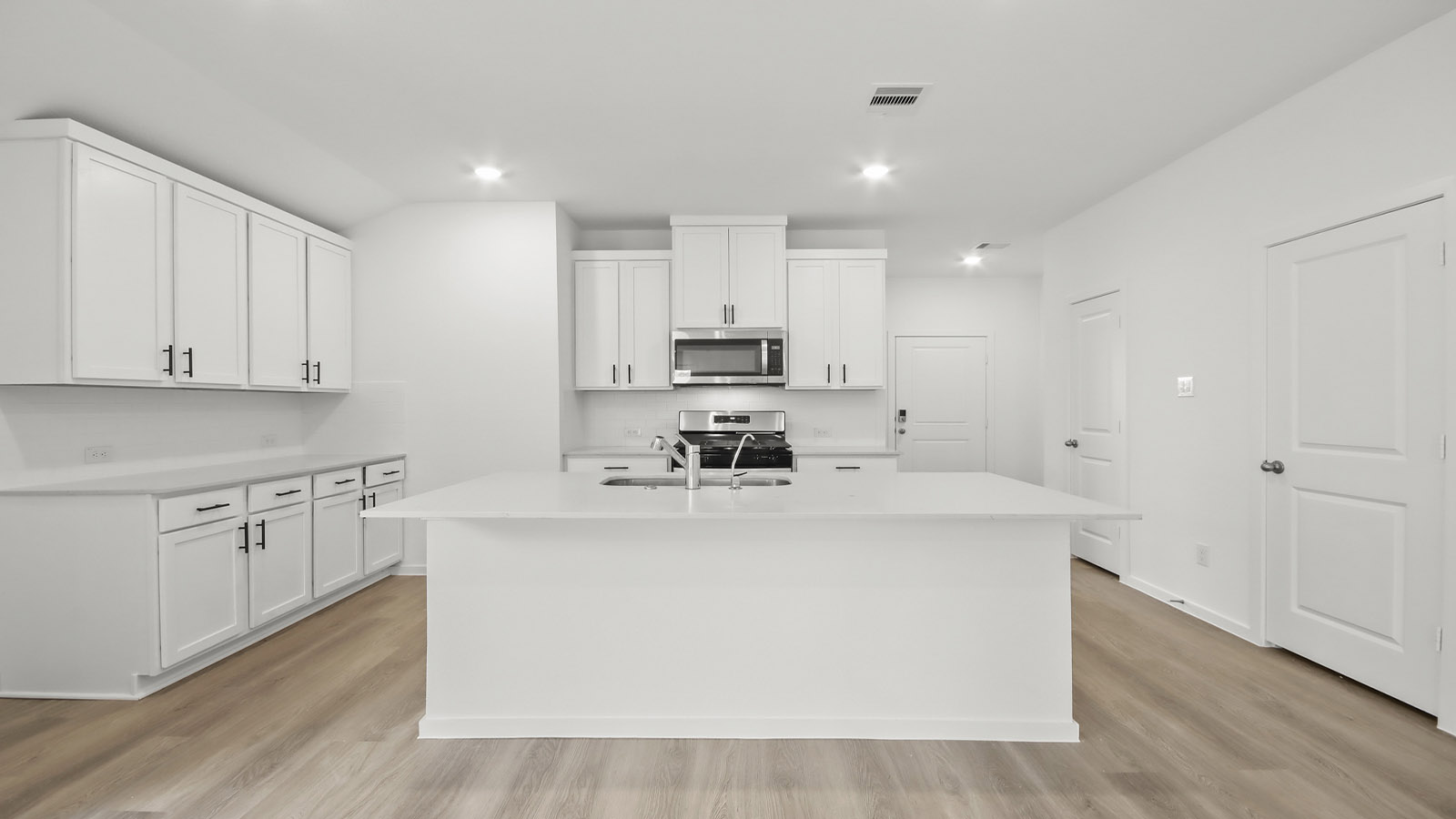 Kitchen with quartz countertops and marden hardware and an island and vinyl floor